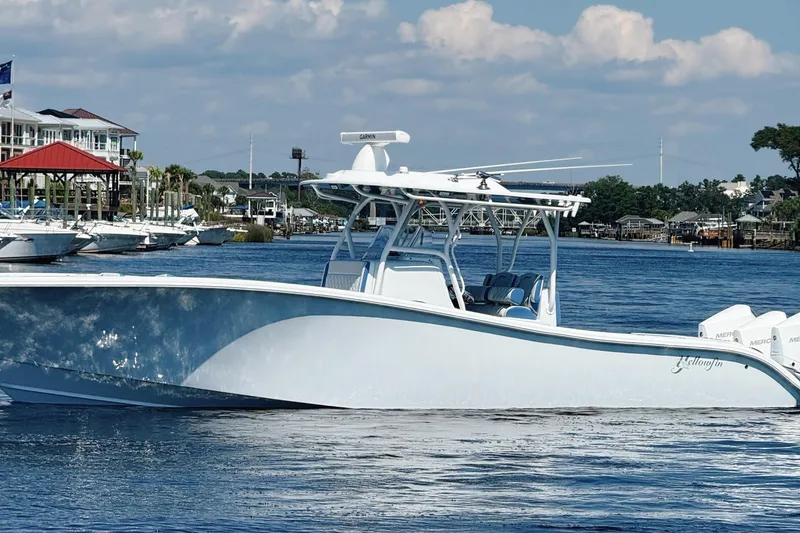 Slide: The Image of 2024 Yellowfin 34 Offshore boat with triple outboard engines on a gravel surface. - 29