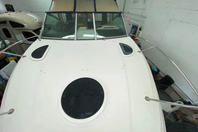 Slide: The Image of 2012 Four Winns V305 boat deck with windows and railing in a garage setting. - 14