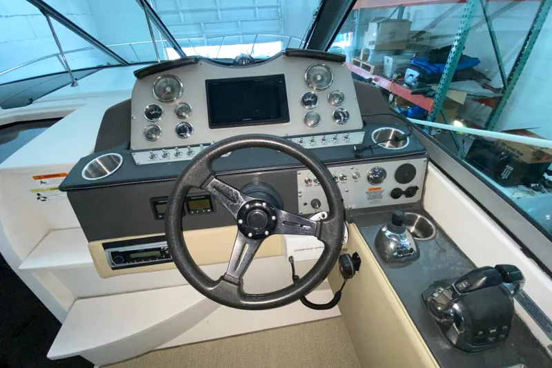 Slide: The Image of 2012 Four Winns V305 boat dashboard with steering wheel and control panel. - 21