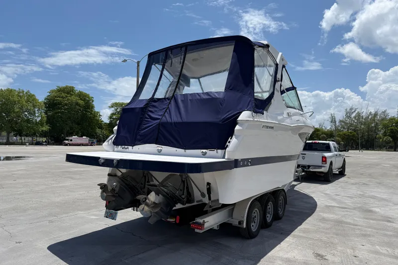 Slide: The Image of 2012 Four Winns V305 boat on trailer, parked outdoors under a clear sky. - 29