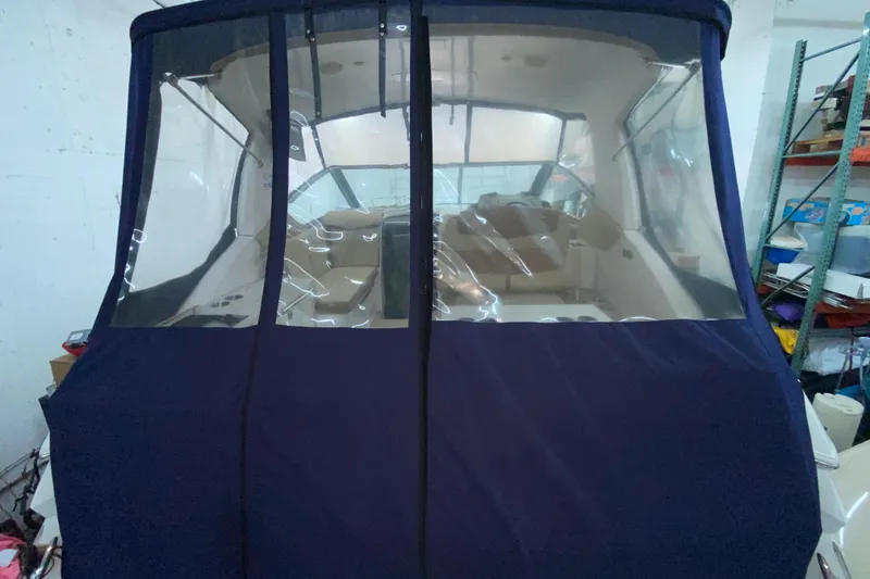 Slide: The Image of 2012 Four Winns V305 boat with blue canvas cover in storage. - 31
