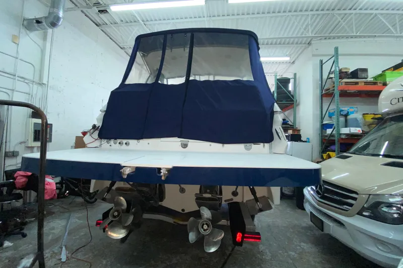 Slide: The Image of 2012 Four Winns V305 boat in garage, covered with blue canvas. - 32