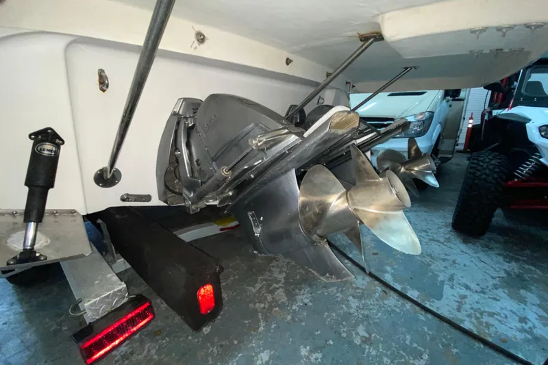 Slide: The Image of 2012 Four Winns V305 boat propeller and stern drive in a garage setting. - 33