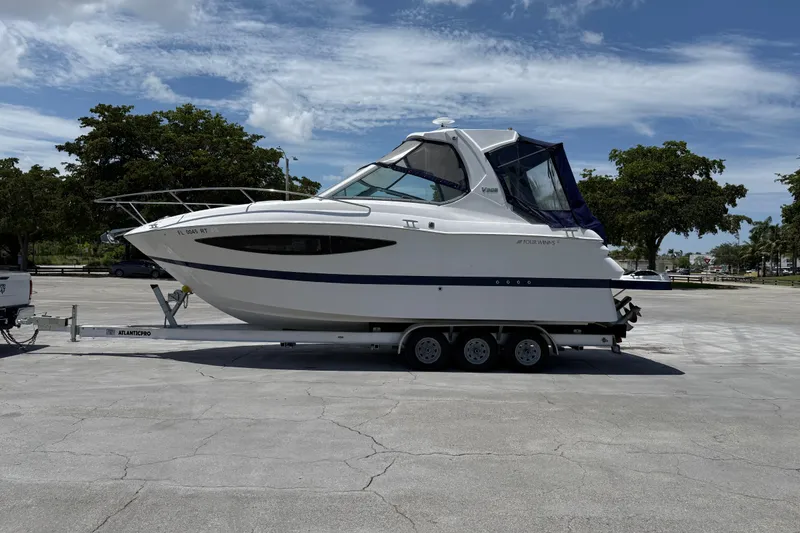 Slide: The Image of 2012 Four Winns V305 boat on trailer in sunny parking lot. - 6