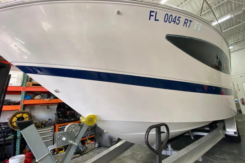 Slide: The Image of 2012 Four Winns V305 boat on trailer in a garage setting. - 7