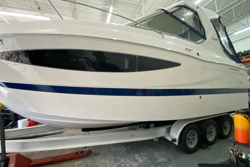 Slide: The Image of 2012 Four Winns V305 boat on trailer in indoor storage facility. - 9