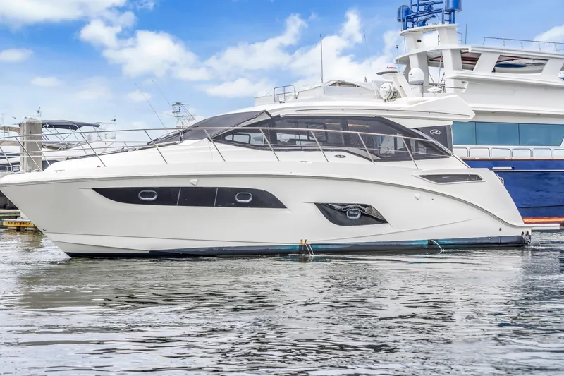Slide: The Image of 2017 Sea Ray Sundancer 460 yacht docked in marina, under blue sky. - 0