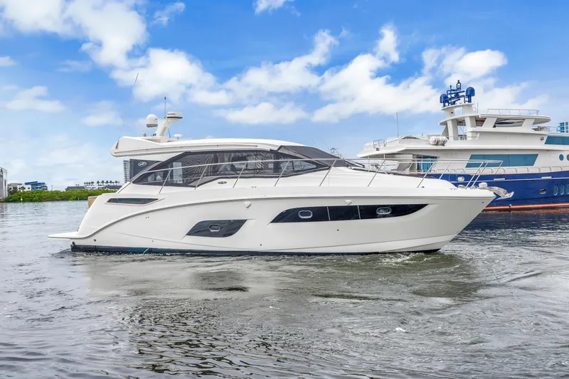 Slide: The Image of 2017 Sea Ray Sundancer 460 yacht on calm water, with blue sky background. - 1