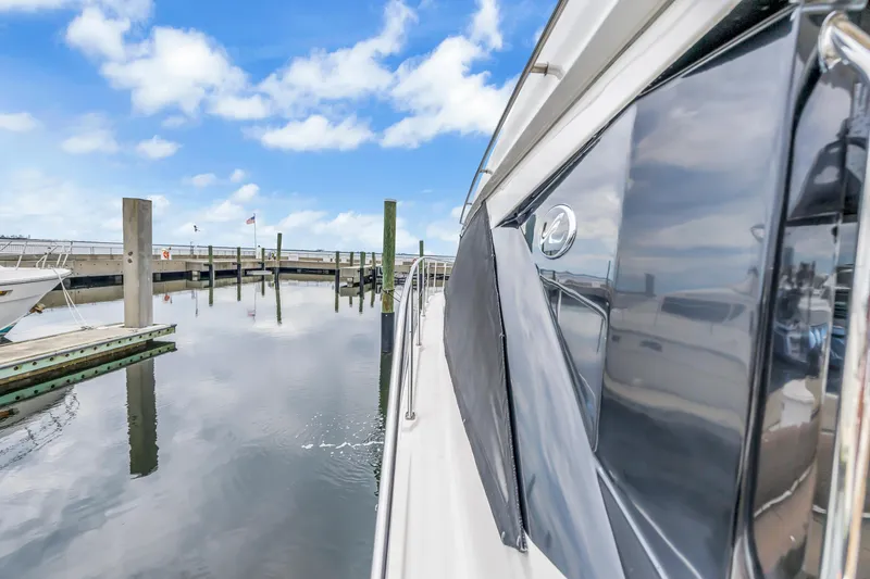 Slide: The Image of 2017 Sea Ray Sundancer 460 yacht docked at a marina under a blue sky. - 16