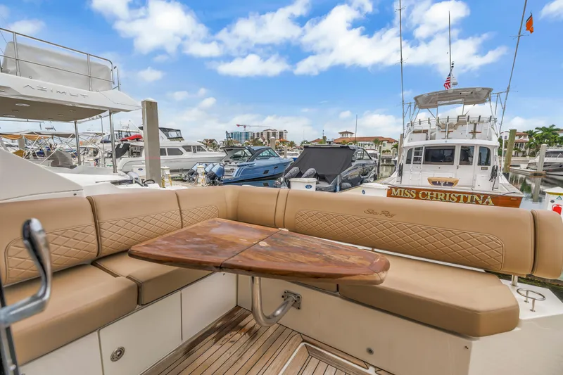 Slide: The Image of 2017 Sea Ray Sundancer 460 yacht with elegant seating and wooden table in a marina. - 21