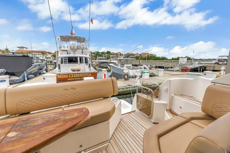 Slide: The Image of 2017 Sea Ray Sundancer 460 yacht docked at marina, featuring luxurious seating and wooden deck. - 22