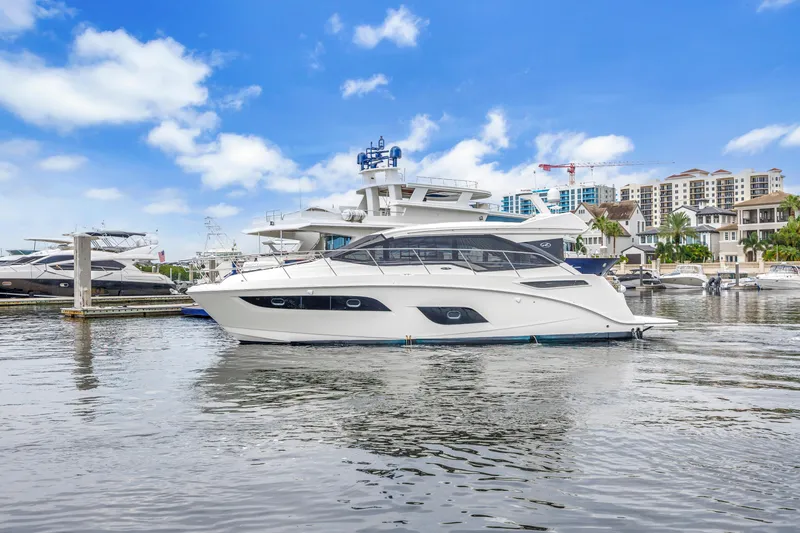 Slide: The Image of 2017 Sea Ray Sundancer 460 yacht docked in a marina with cityscape background. - 4