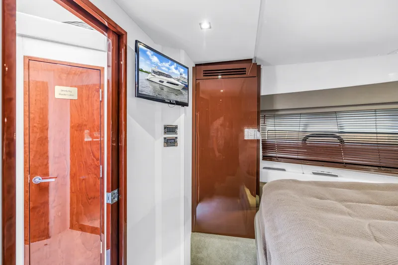 Slide: The Image of Interior of 2017 Sea Ray Sundancer 460 yacht, featuring a cozy cabin with TV and wood finishes. - 42