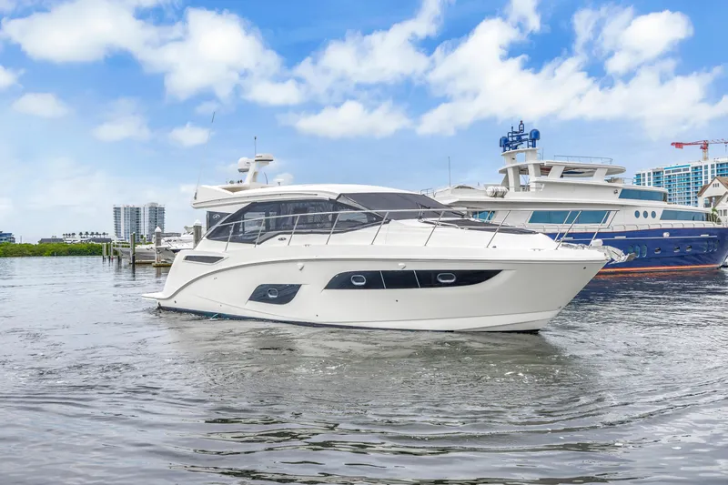 Slide: The Image of 2017 Sea Ray Sundancer 460 yacht on water, with blue sky and cityscape background. - 5