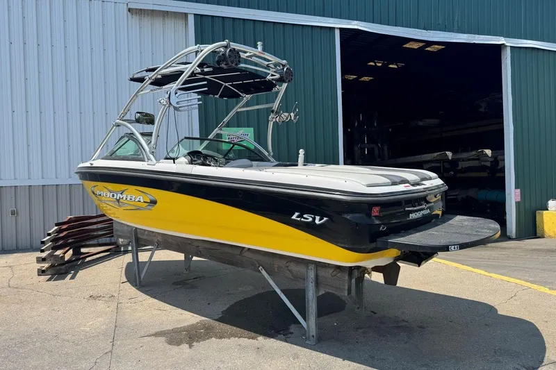 Slide: The Image of 2008 Moomba Mobius LSV boat in yellow and black, parked outside a warehouse. - 3