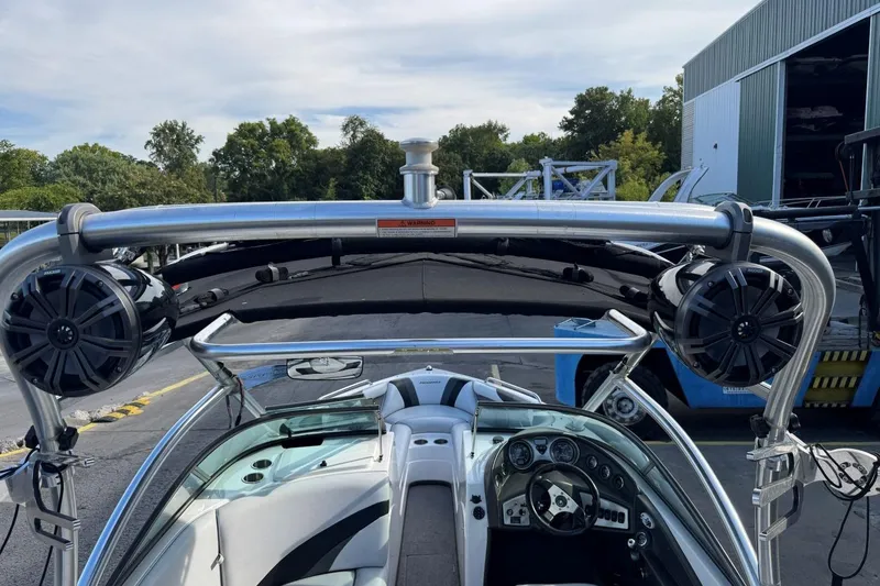 Slide: The Image of 2008 Moomba Mobius LSV boat interior with speakers and steering wheel, docked outdoors. - 41