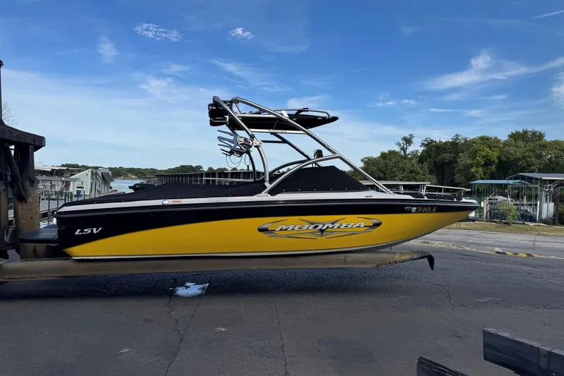 Slide: The Image of 2008 Moomba Mobius LSV boat in yellow and black, docked near a marina. - 43