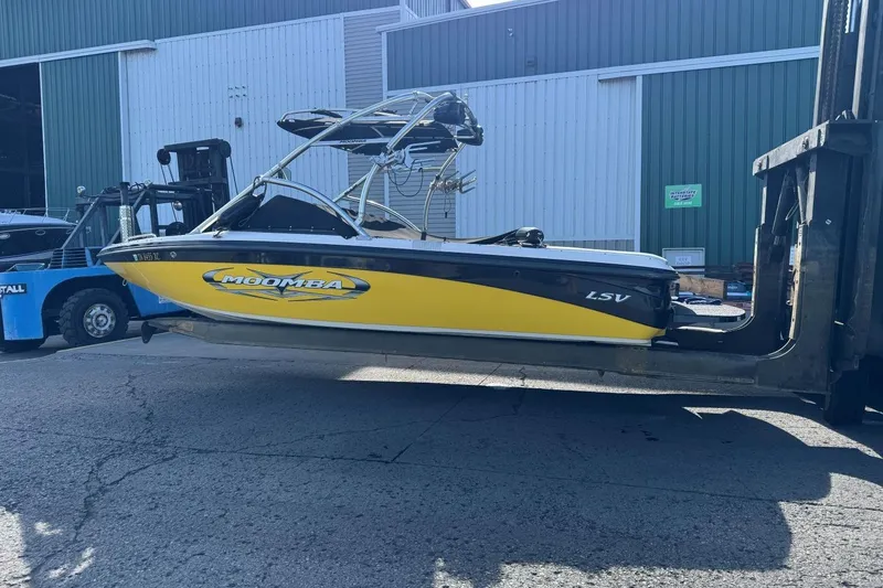 Slide: The Image of 2008 Moomba Mobius LSV boat in yellow, lifted by a forklift near a warehouse. - 44