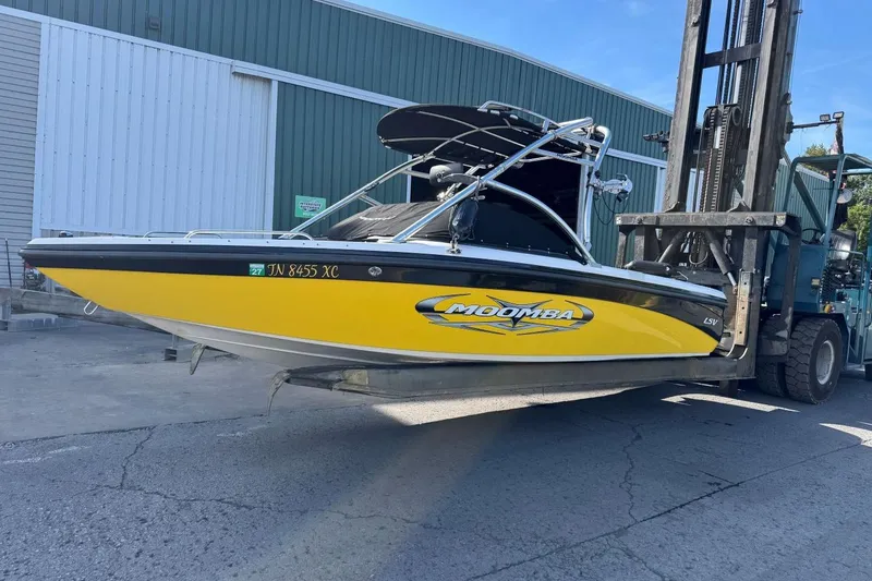 Slide: The Image of 2008 Moomba Mobius LSV boat in yellow, lifted by a forklift near a warehouse. - 6