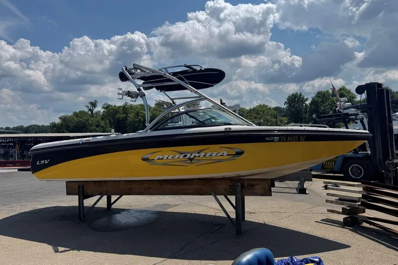 Slide: The Image of 2008 Moomba Mobius LSV boat on display, yellow and black design, sunny day. - 7