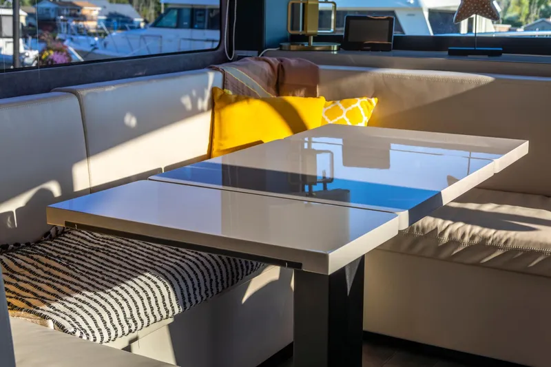 Slide: The Image of Interior of 2018 Cranchi Eco Trawler 53, featuring a sleek dining area with cushions. - 119
