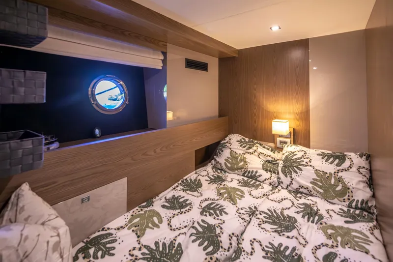 Slide: The Image of Cozy cabin interior of 2018 Cranchi Eco Trawler 53, featuring a comfortable bed and porthole window. - 137