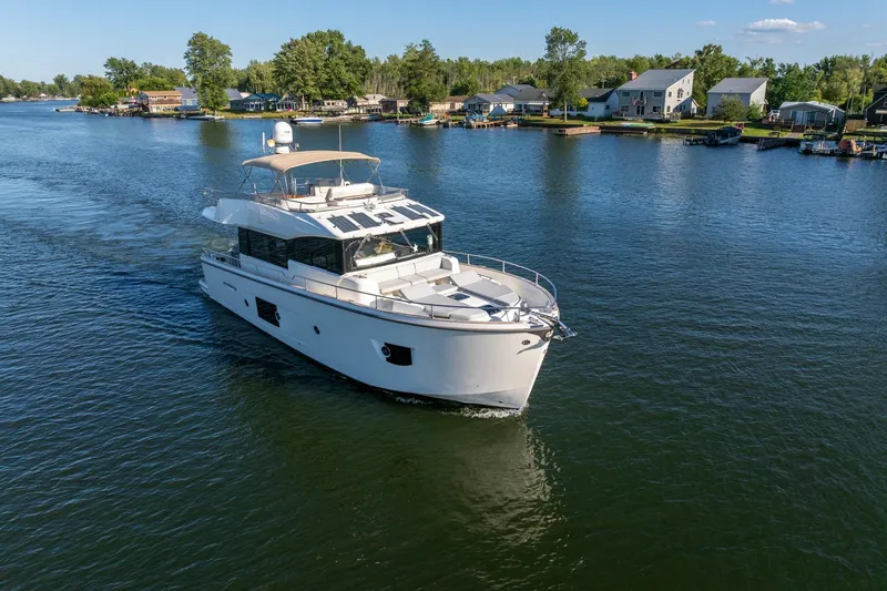 Slide: The Image of 2018 Cranchi Eco Trawler 53 Long Distance cruising on a serene lake near waterfront homes. - 4