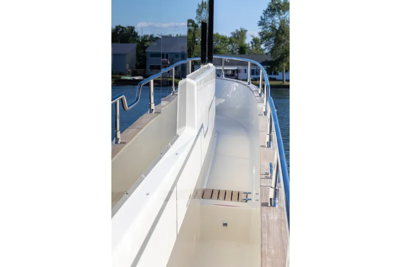 Slide: The Image of 2018 Cranchi Eco Trawler 53 Long Distance yacht deck with railing, docked by water. - 57
