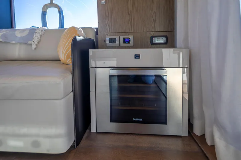 Slide: The Image of Interior of 2018 Cranchi Eco Trawler 53, featuring a modern kitchen appliance and cozy seating. - 93