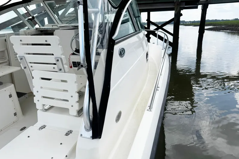 Slide: The Image of 2005 Pursuit 2870 Walkaround boat docked near wooden pier. - 15