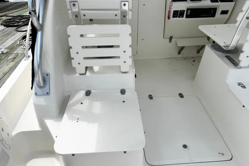 Slide: The Image of 2005 Pursuit 2870 Walkaround boat interior with white seating and control panel. - 16