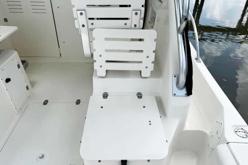 Slide: The Image of 2005 Pursuit 2870 Walkaround boat interior with white seating and storage compartments. - 17
