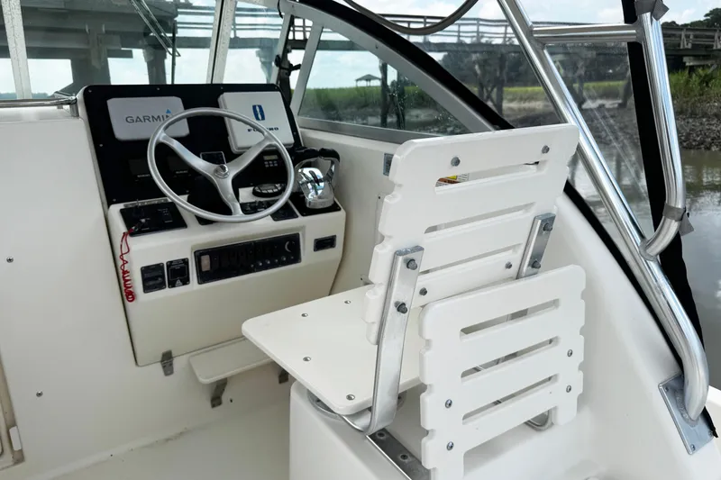 Slide: The Image of 2005 Pursuit 2870 Walkaround boat helm with steering wheel and Garmin navigation system. - 18