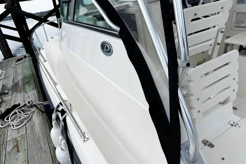 Slide: The Image of 2005 Pursuit 2870 Walkaround boat docked, showcasing sleek design and sturdy construction. - 22