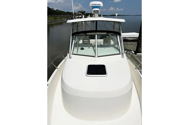 Slide: The Image of 2005 Pursuit 2870 Walkaround boat docked by calm waters. - 24