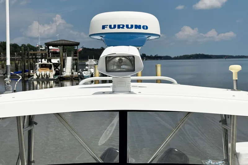 Slide: The Image of 2005 Pursuit 2870 Walkaround boat with Furuno radar, docked by calm waters. - 27