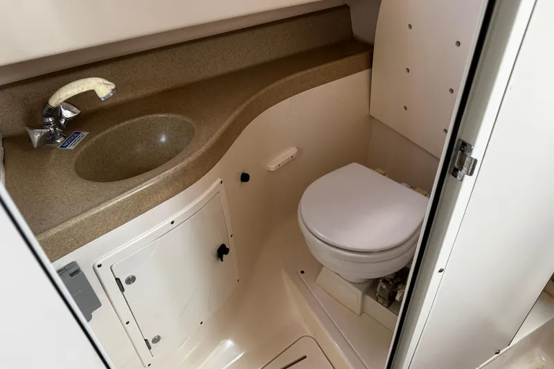 Slide: The Image of 2005 Pursuit 2870 Walkaround boat bathroom with sink and toilet. - 38