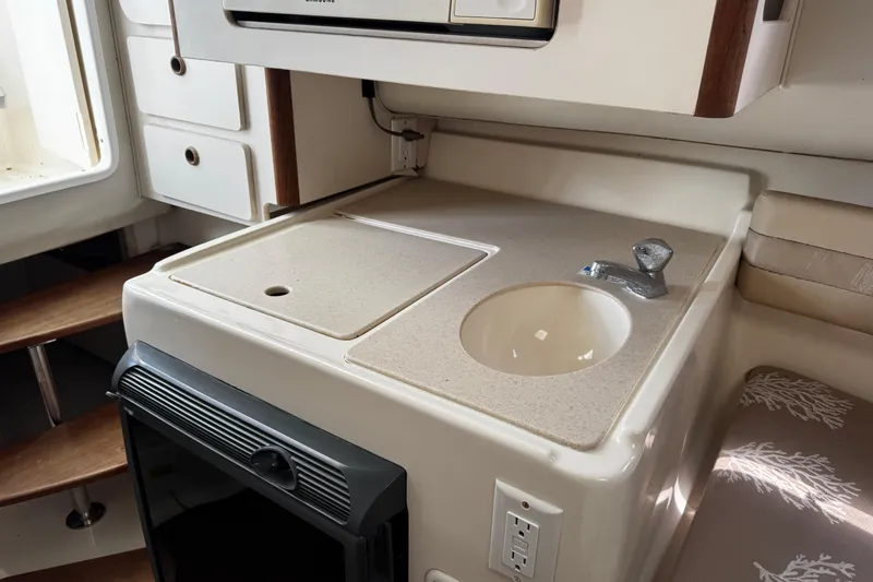 Slide: The Image of 2005 Pursuit 2870 Walkaround boat interior with compact kitchenette and sink. - 39