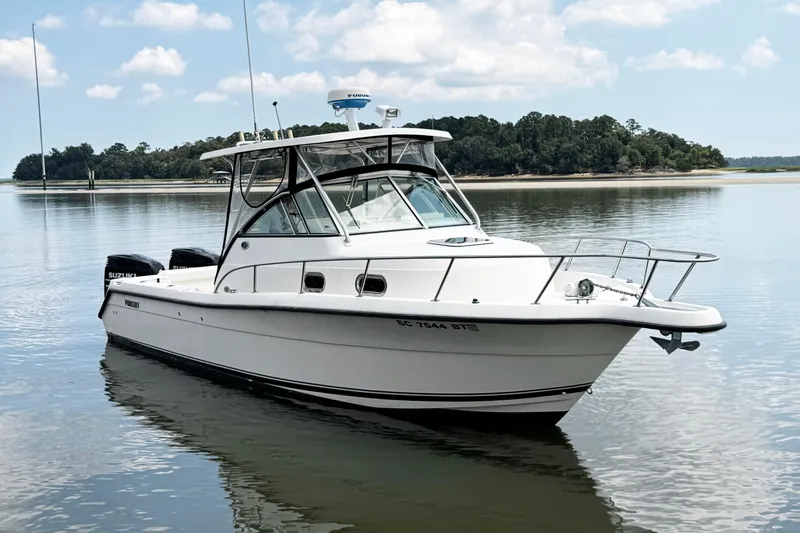 Slide: The Image of 2005 Pursuit 2870 Walkaround boat on calm water with scenic background. - 4