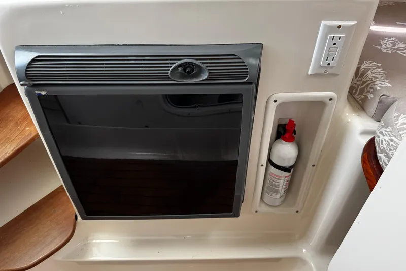 Slide: The Image of 2005 Pursuit 2870 Walkaround interior with fridge, fire extinguisher, and power outlet. - 41