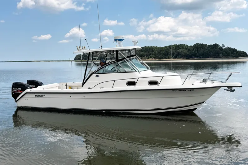 Slide: The Image of 2005 Pursuit 2870 Walkaround boat on calm water, clear sky, and distant shoreline. - 5