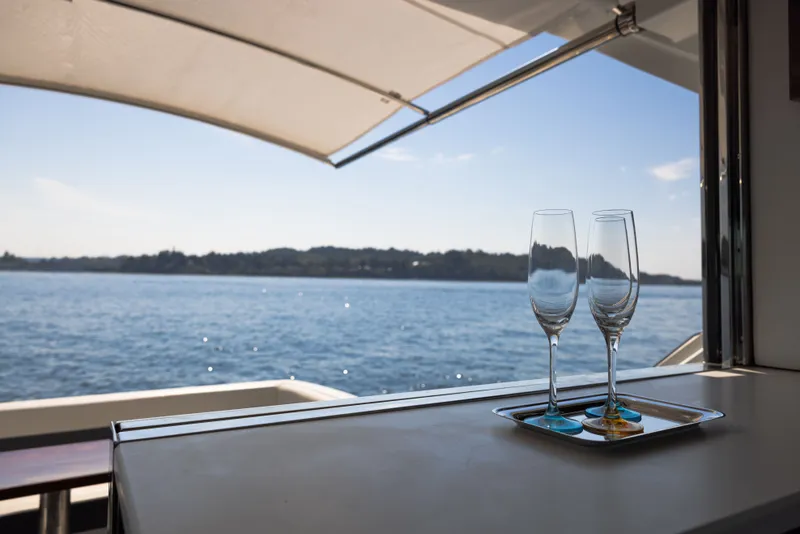 Slide: The Image of Two champagne glasses on a yacht overlooking the ocean, Cruisers Yachts 50 Cantius 2019. - 13