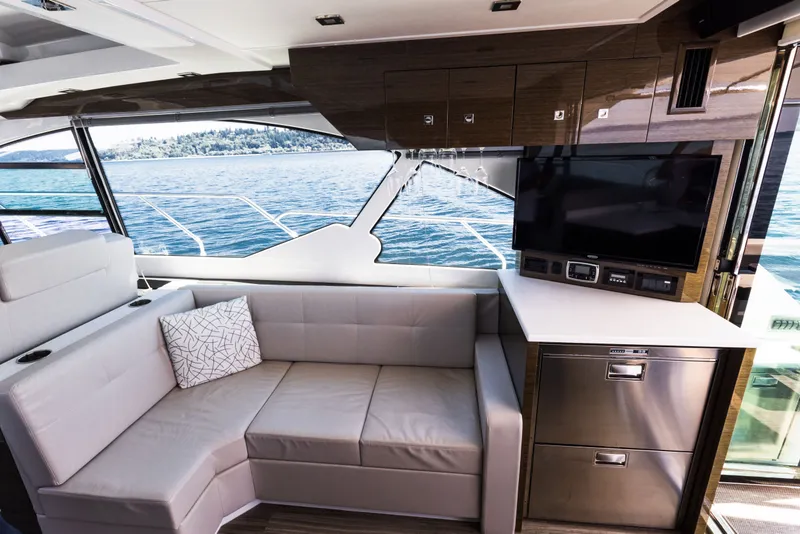 Slide: The Image of Luxurious interior of 2019 Cruisers Yachts 50 Cantius with sofa, TV, and scenic ocean view. - 22