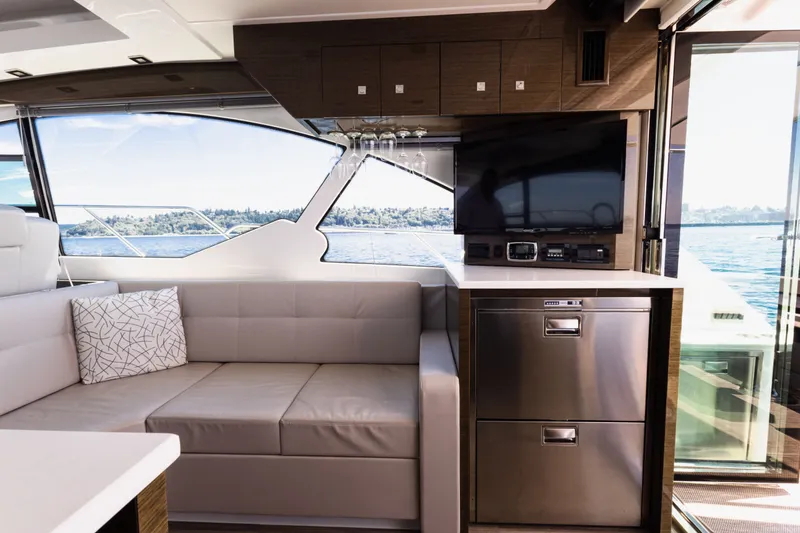 Slide: The Image of Luxurious interior of 2019 Cruisers Yachts 50 Cantius with sofa, TV, and scenic window view. - 24