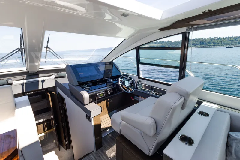 Slide: The Image of 2019 Cruisers Yachts 50 Cantius helm with modern controls and panoramic water view. - 27
