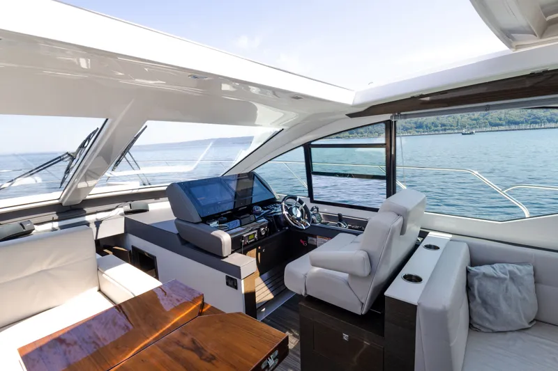 Slide: The Image of Luxurious 2019 Cruisers Yachts 50 Cantius interior with modern helm and seating, overlooking serene waters. - 29
