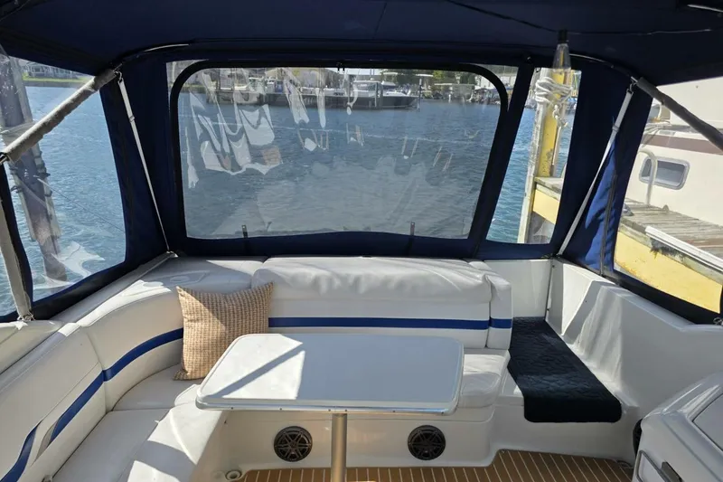 Slide: The Image of Interior of 2002 Formula 330 Sun Sport boat with seating and table, docked by water. - 10