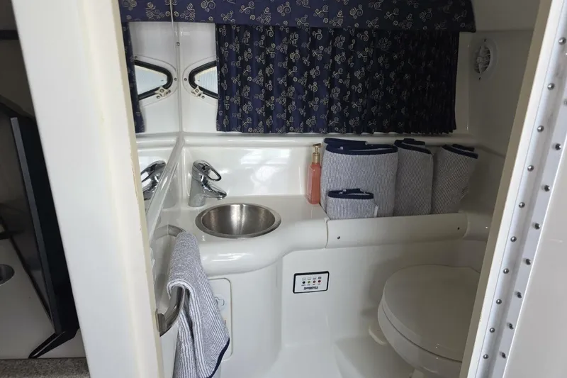 Slide: The Image of 2002 Formula 330 Sun Sport boat bathroom with sink, toilet, and nautical-themed decor. - 23