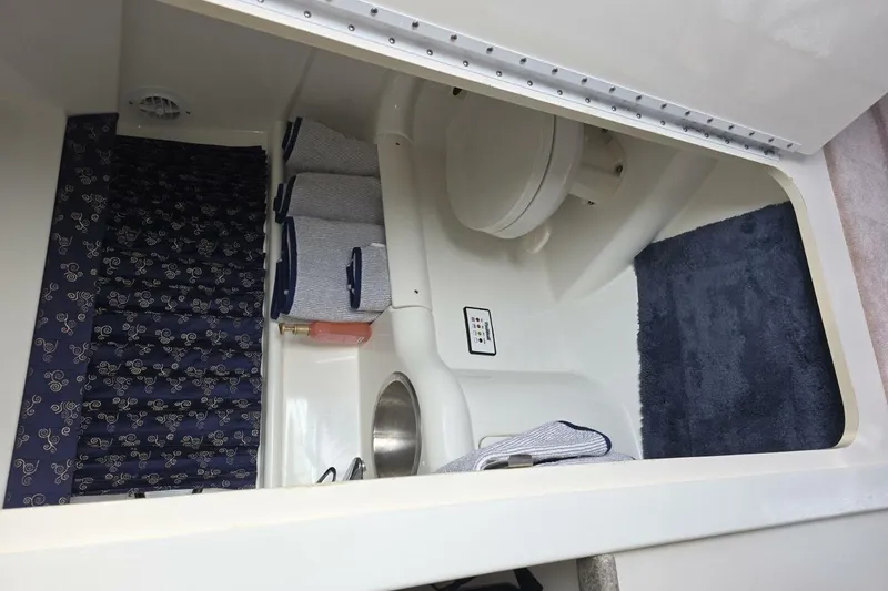 Slide: The Image of 2002 Formula 330 Sun Sport boat bathroom with toilet, sink, and blue decor. - 25