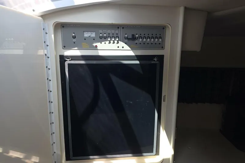 Slide: The Image of Control panel and refrigerator inside a 2002 Formula 330 Sun Sport boat. - 26